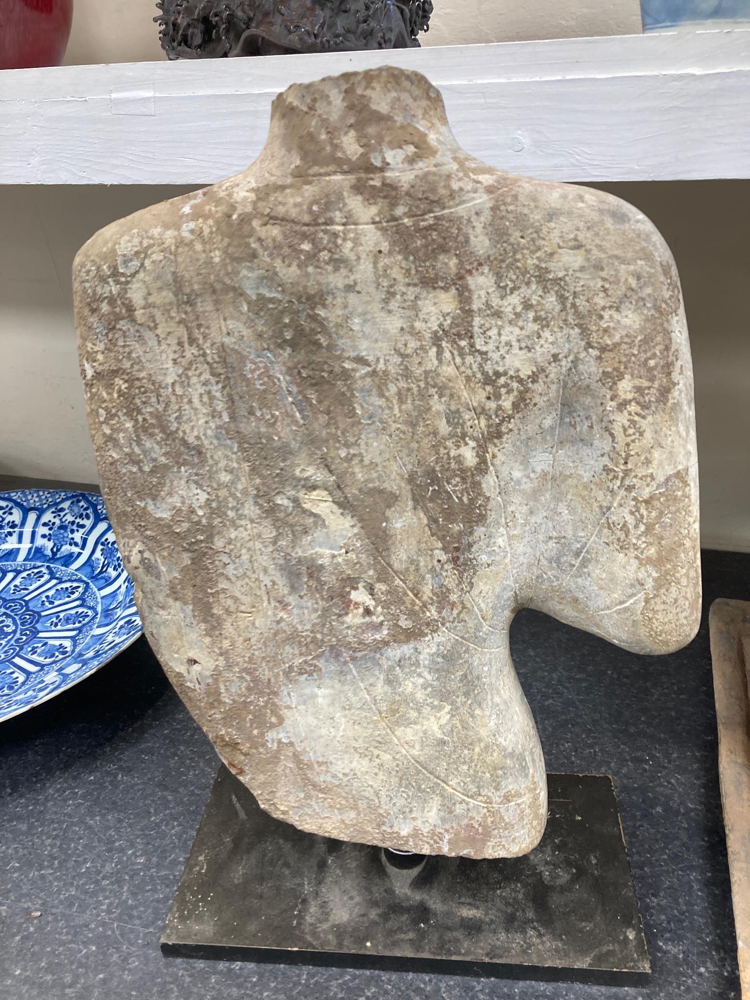 A Chinese pigment painted limestone torso of Buddha, probably Northern Qi dynasty (550-577 CE), 36cm high, mounted on a later base, total height 42.5cm